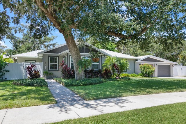 single story home featuring a garage and a front lawn