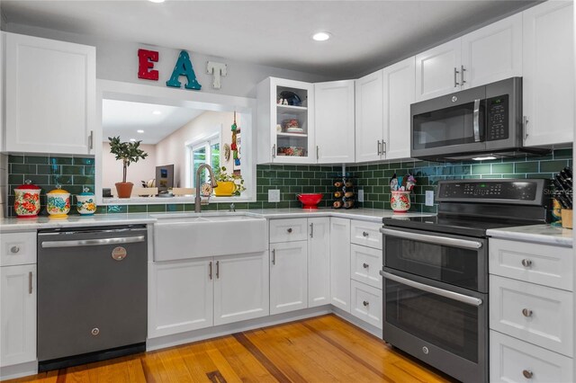 kitchen with white cabinets, appliances with stainless steel finishes, and sink