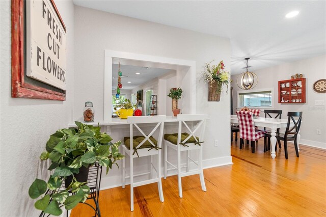 dining area with wood-type flooring and a chandelier