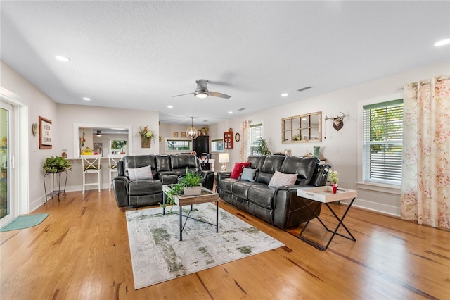 living room featuring light hardwood / wood-style floors and ceiling fan