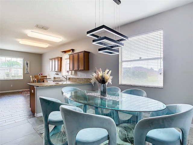 kitchen featuring hanging light fixtures, kitchen peninsula, and sink