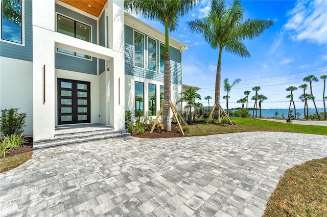 doorway to property with french doors and a water view