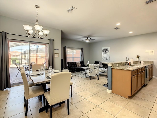 tiled dining area with ceiling fan with notable chandelier and sink