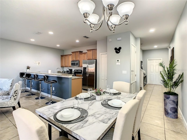 dining area with light tile patterned floors and an inviting chandelier