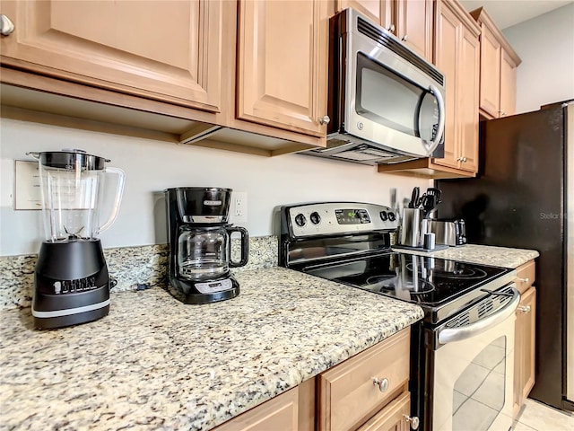 kitchen featuring stainless steel appliances, light tile patterned floors, and light stone countertops