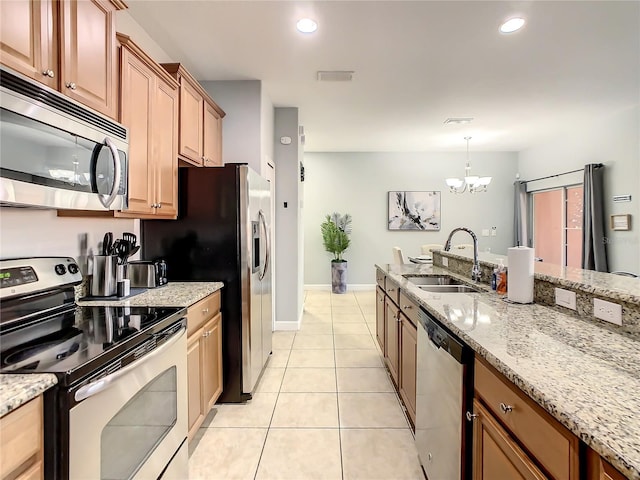 kitchen featuring decorative light fixtures, light stone countertops, stainless steel appliances, a notable chandelier, and sink