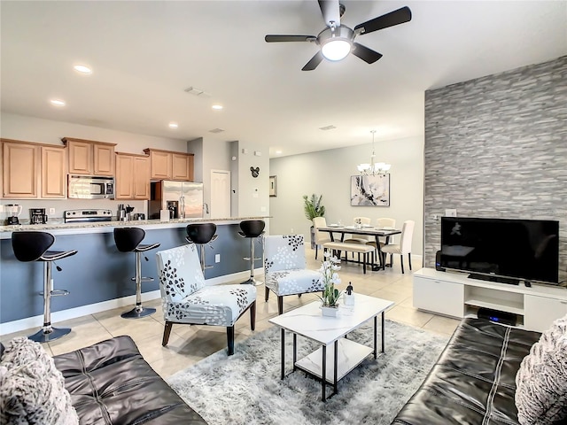 tiled living room with ceiling fan with notable chandelier