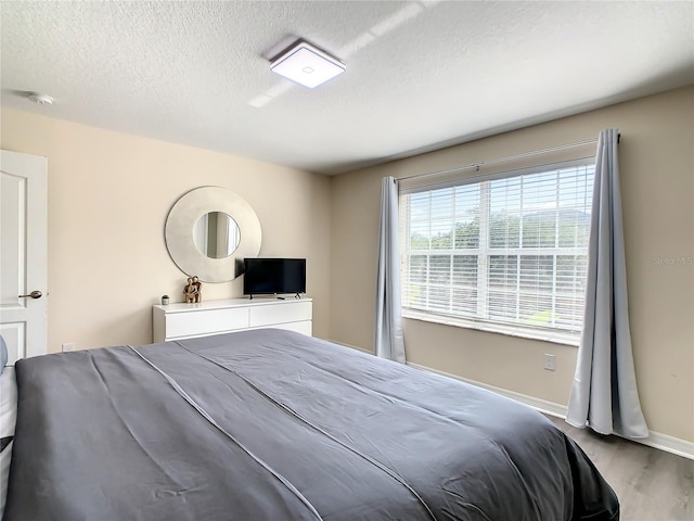 bedroom featuring a textured ceiling and light wood-type flooring