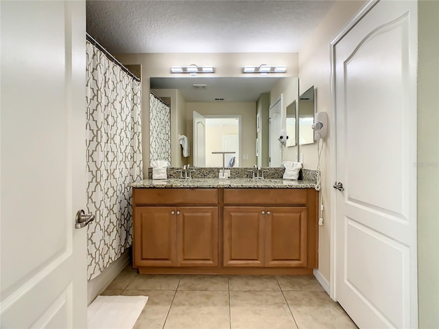 bathroom featuring a textured ceiling, vanity, curtained shower, and tile patterned floors