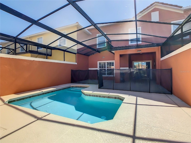 view of pool with a patio area and glass enclosure