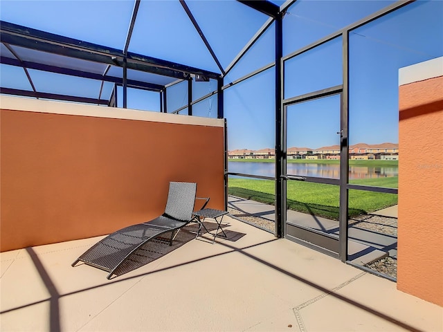 view of patio / terrace with glass enclosure and a water view