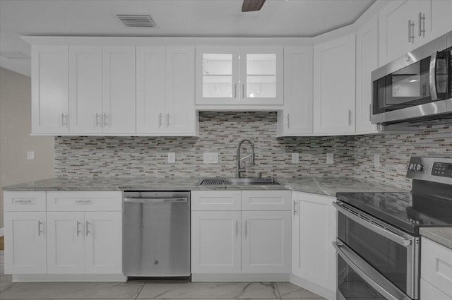 kitchen featuring white cabinets, appliances with stainless steel finishes, and sink