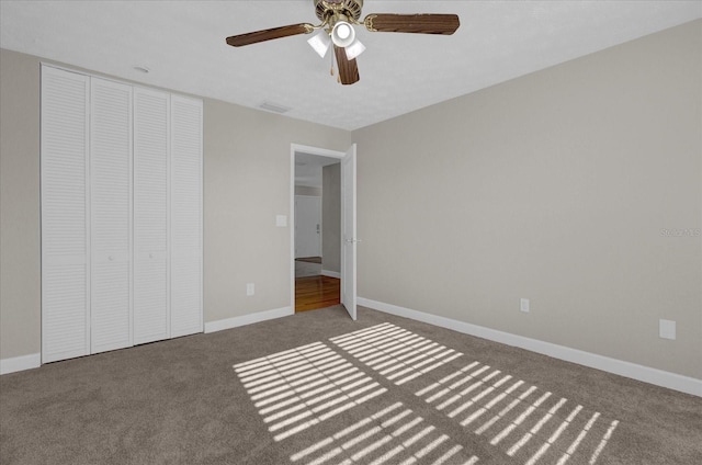 unfurnished bedroom featuring ceiling fan, a closet, and carpet floors