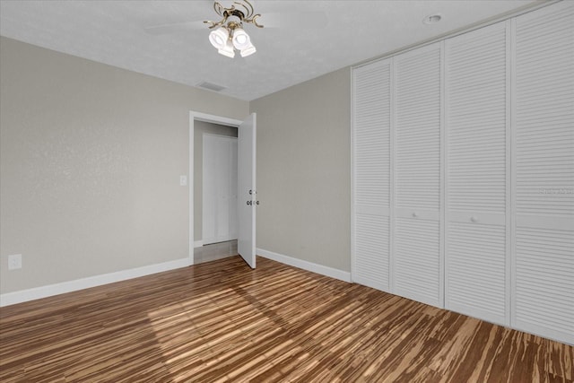 unfurnished bedroom featuring a closet, ceiling fan, hardwood / wood-style floors, and a textured ceiling