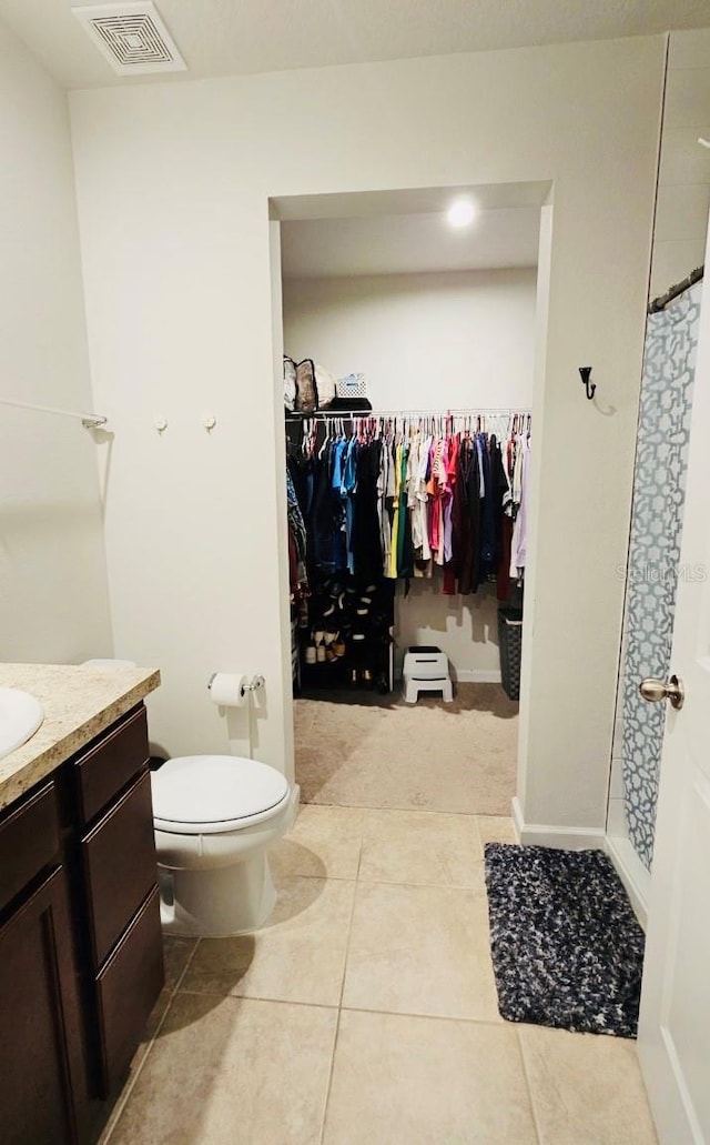 bathroom with a shower with curtain, tile patterned flooring, toilet, and vanity