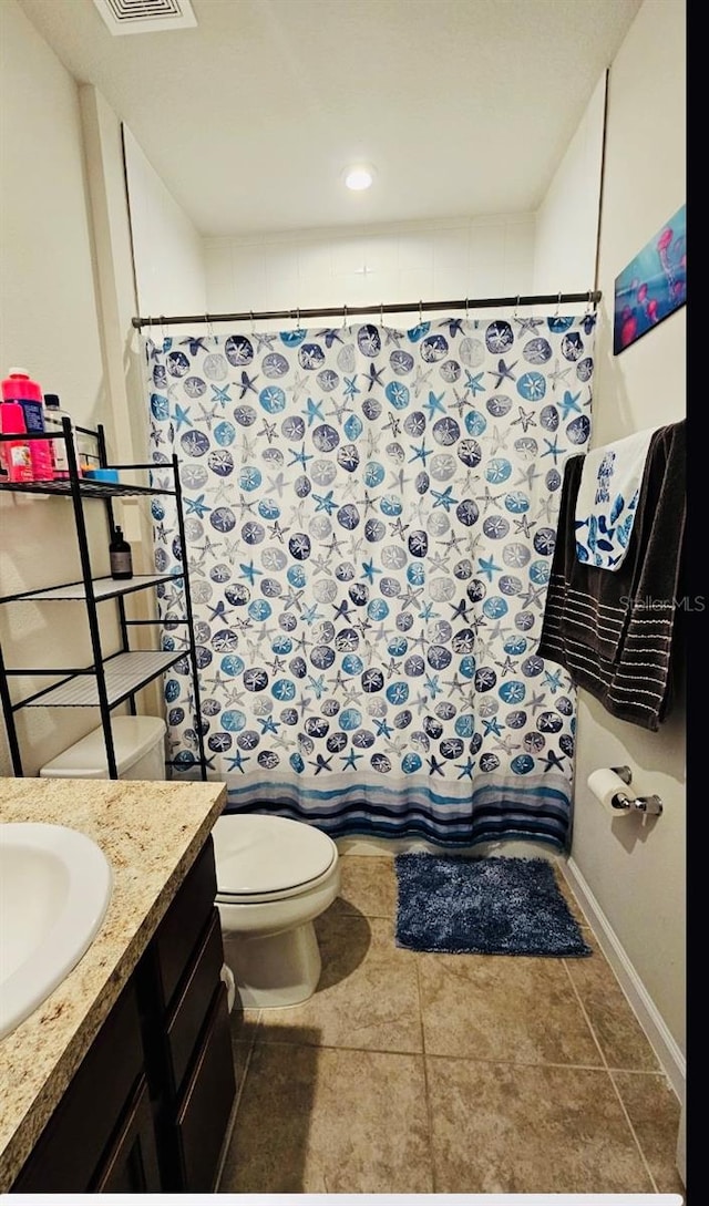 bathroom with vanity, toilet, walk in shower, and tile patterned flooring