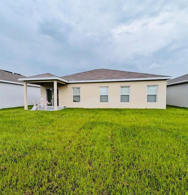 rear view of house featuring a yard and a patio area