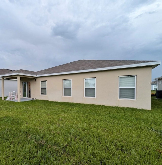 rear view of property with a yard and a patio