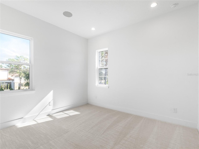 spare room with light colored carpet and a healthy amount of sunlight