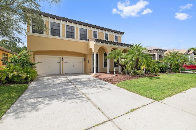 mediterranean / spanish-style home with a garage, stucco siding, a front yard, a tiled roof, and driveway