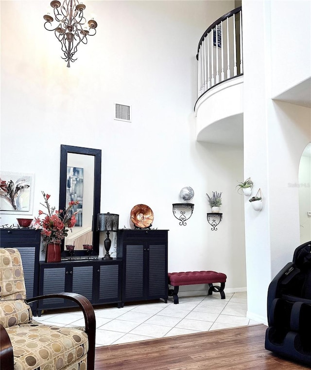 living room featuring a high ceiling, visible vents, and tile patterned floors