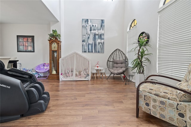 sitting room with wood finished floors and a towering ceiling