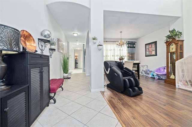 living area with an inviting chandelier, baseboards, and light tile patterned flooring