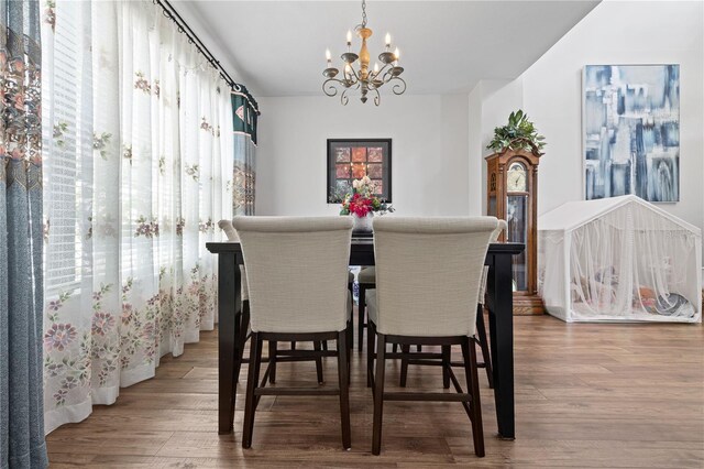 dining space featuring wood finished floors and a chandelier