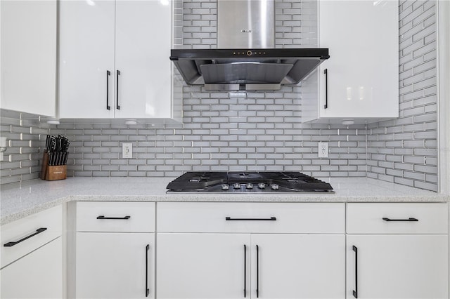 kitchen featuring white cabinetry, decorative backsplash, stainless steel gas stovetop, and range hood
