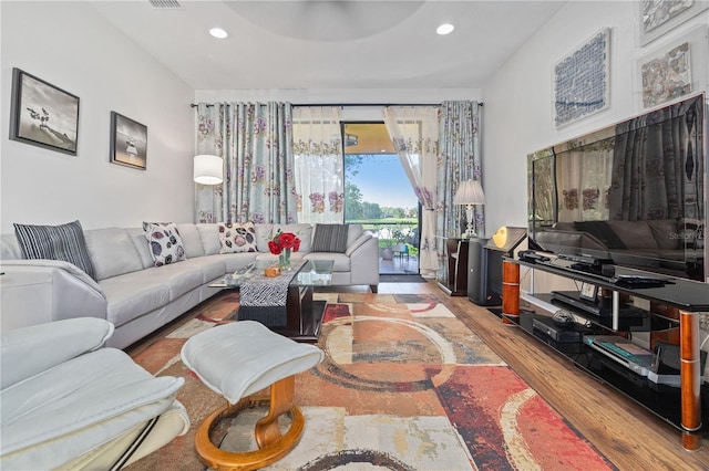 living area with recessed lighting, wood finished floors, and visible vents