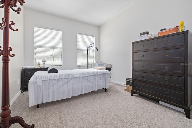 bedroom with light colored carpet and baseboards
