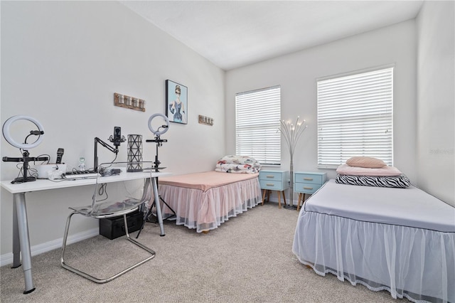 bedroom with baseboards and light colored carpet