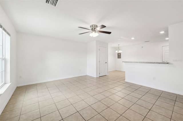 unfurnished living room featuring light tile patterned floors, electric panel, and ceiling fan with notable chandelier