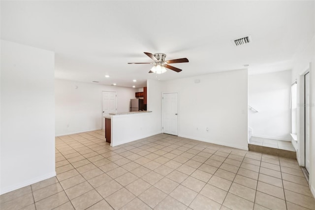 empty room with ceiling fan and light tile patterned flooring