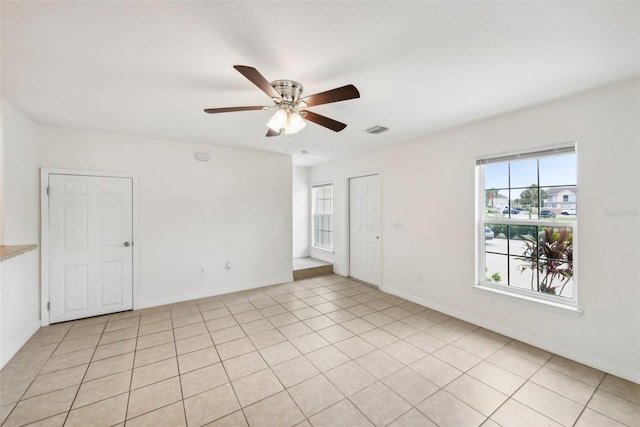 tiled empty room featuring ceiling fan