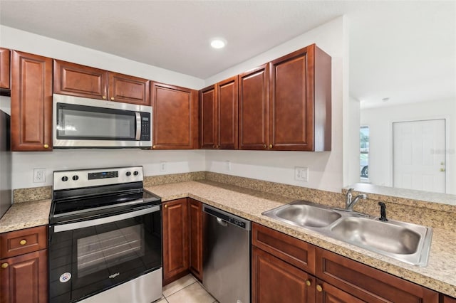 kitchen featuring appliances with stainless steel finishes, light tile patterned floors, and sink