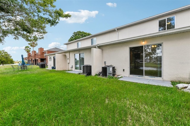 back of property with a patio area, a lawn, and central AC unit