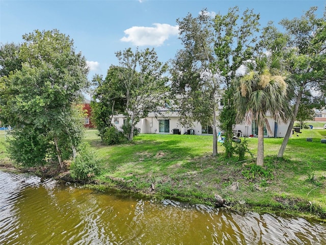 view of dock featuring a lawn and a water view