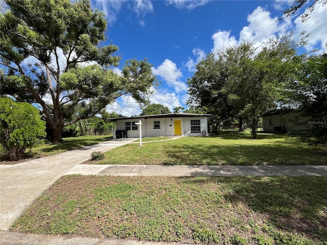 ranch-style home featuring a carport and a front lawn