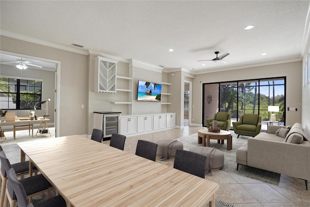 dining space with ornamental molding, ceiling fan, light tile patterned floors, and a textured ceiling