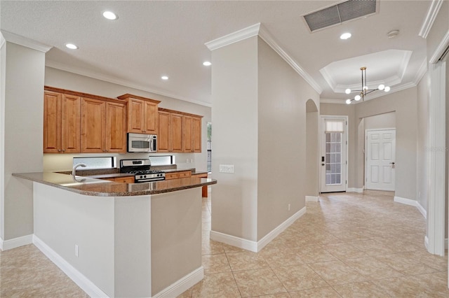 kitchen featuring pendant lighting, a notable chandelier, kitchen peninsula, appliances with stainless steel finishes, and crown molding