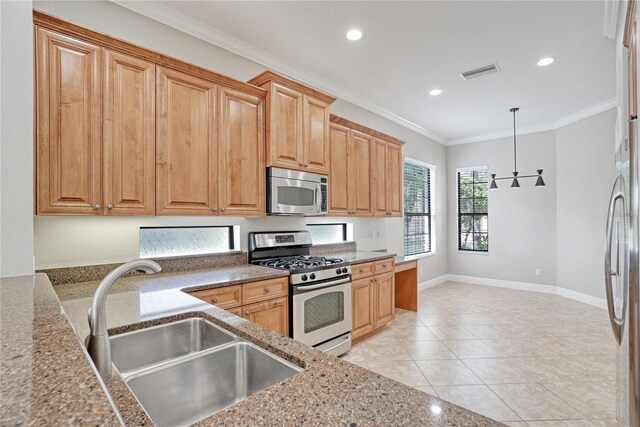 kitchen with light tile patterned flooring, pendant lighting, stainless steel appliances, ornamental molding, and sink