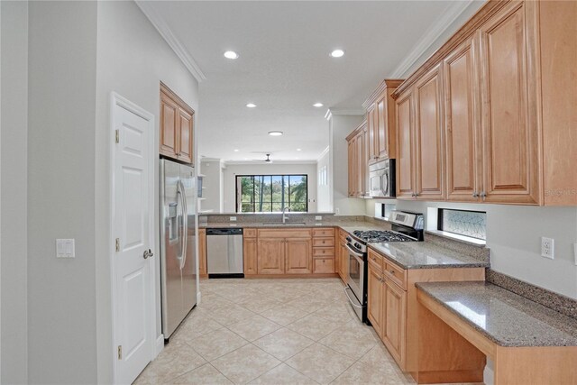 kitchen with ornamental molding, appliances with stainless steel finishes, sink, and dark stone counters