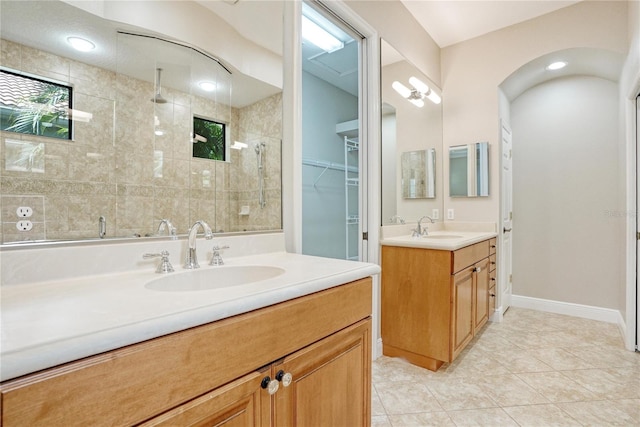 bathroom with a tile shower, tile patterned floors, and vanity