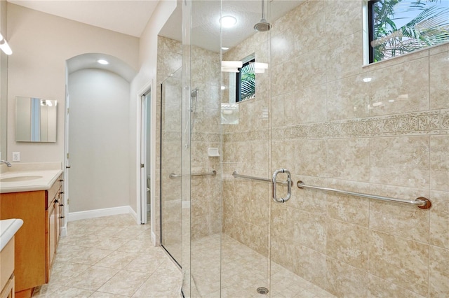 bathroom featuring tile patterned floors, an enclosed shower, and vanity