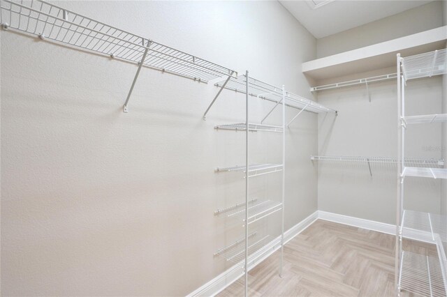 spacious closet featuring light parquet floors