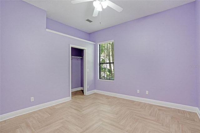 spare room with ceiling fan and light parquet flooring