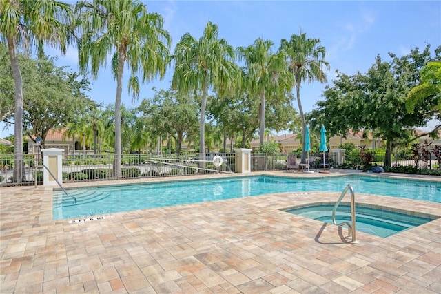 view of swimming pool featuring a community hot tub and a patio area