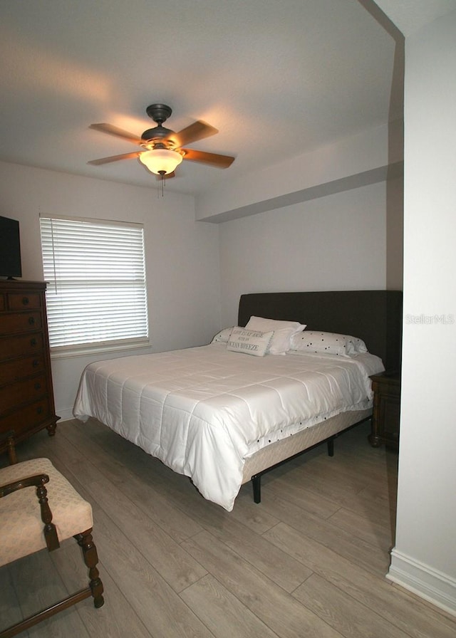 bedroom with light wood-style floors and a ceiling fan