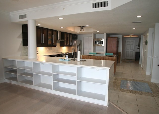 kitchen with open shelves, wall chimney exhaust hood, visible vents, and stainless steel appliances